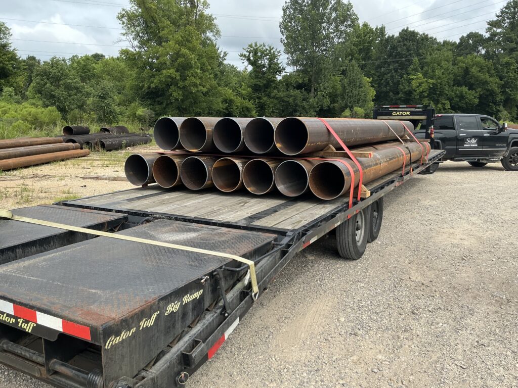 Pipe load strapped on a SoReel Outdoors 40 foot flatbed